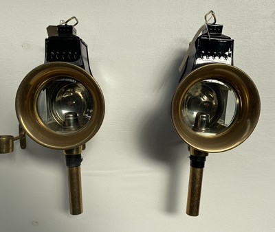 Lot 900 - Pair of black and brass round fronted carriage lamps by Holland & Holland of London, height 20"