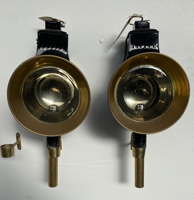 Lot 901 - Pair of large black and brass round fronted carriage lamps by Holland & Holland, height 24"
