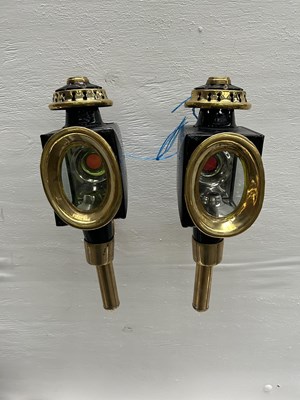 Lot 1021 - Pair of black and brass oval fronted lamps. This lot carries VAT.