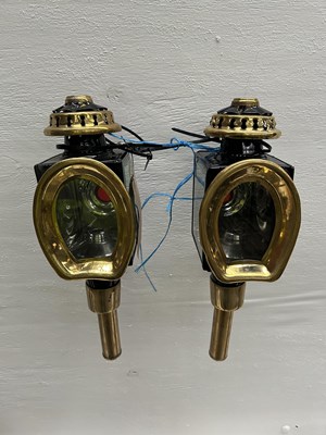 Lot 1034 - Pair of black and brass horseshoe-fronted lamps. This lot carries VAT.