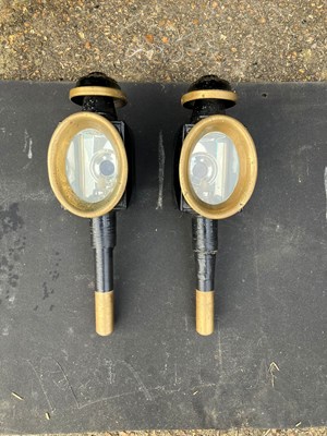 Lot 1109 - Pair of black and brass oval-fronted lamps