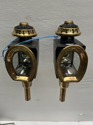 Lot 1144 - Pair of black and brass horseshoe-fronted lamps. This lot carries VAT.