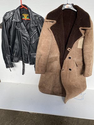 Lot 1233 - Black leather jacket, size 44; together with a sheepskin coat size 44