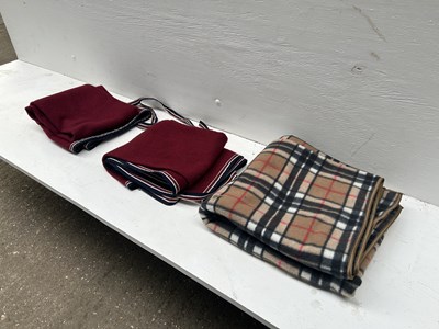 Lot 1283 - Checked driving apron together with two maroon driving aprons