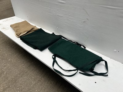 Lot 1286 - Two green driving aprons together with a brown driving apron