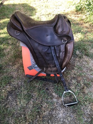 Lot 315 - 17" brown leather saddle with stirrups